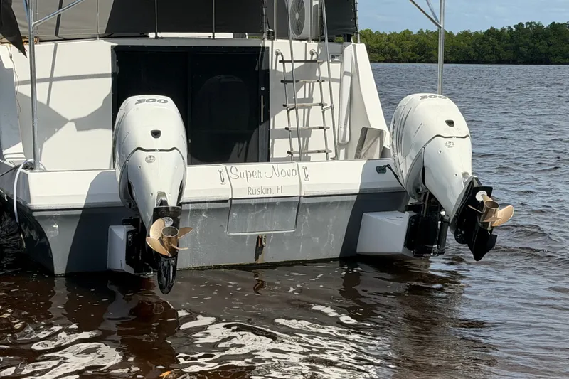 Slide: The Image of 1987 Bluewater Yachts Coastal Cruiser 51 with dual outboard motors on water. - 12