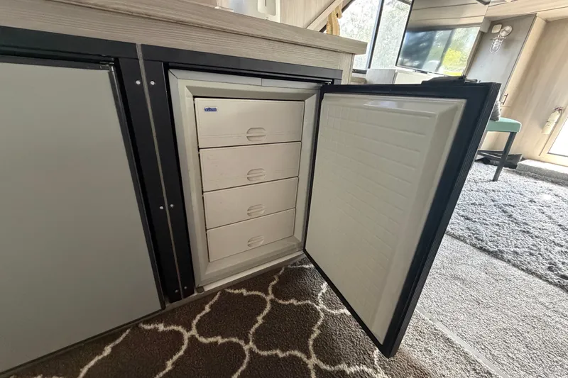 Slide: The Image of Open refrigerator with drawers inside a 1987 Bluewater Yachts Coastal Cruiser 51. - 57