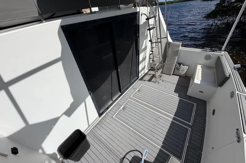 Slide: The Image of 1987 Bluewater Yachts Coastal Cruiser 51 deck with seating, ladder, and water view. - 19