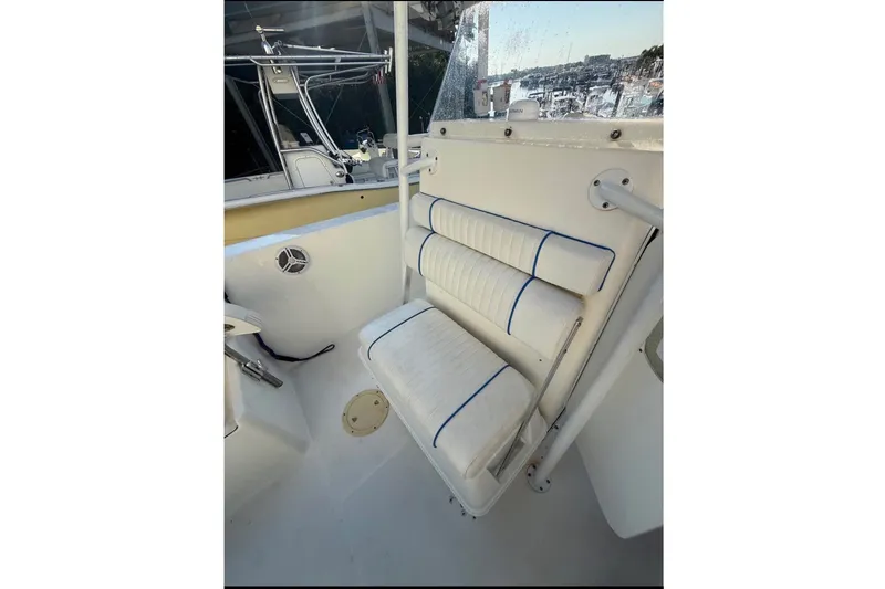 Slide: The Image of The 2004 Sea Fox 257 Center Console features a cushioned bench seat with blue accents. - 16