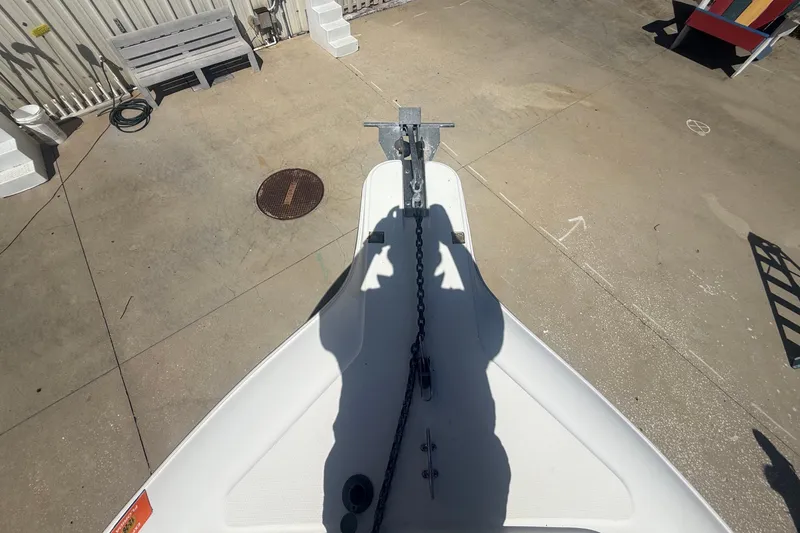 Slide: The Image of The bow of a white boat with anchor and chain on a concrete surface. - 38