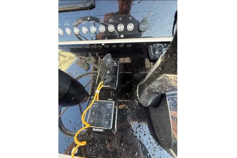 Slide: The Image of Close-up of the helm of a 2004 Sea Fox 257 Center Console boat with Suzuki controls. - 9