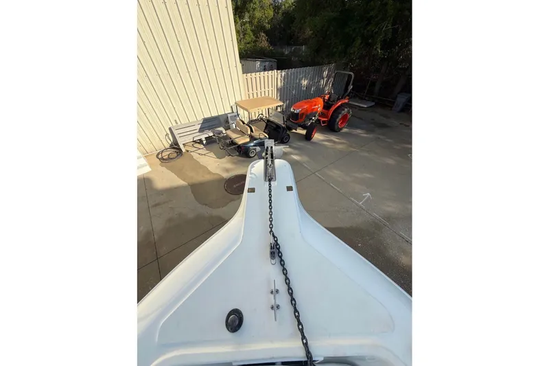 Slide: The Image of Bow of a boat with anchor chain, a tractor and building in the background. - 17