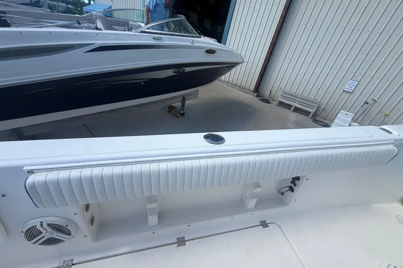 Slide: The Image of 2004 Sea Fox 257 Center Console boat docked near a warehouse, showcasing sleek design. - 48