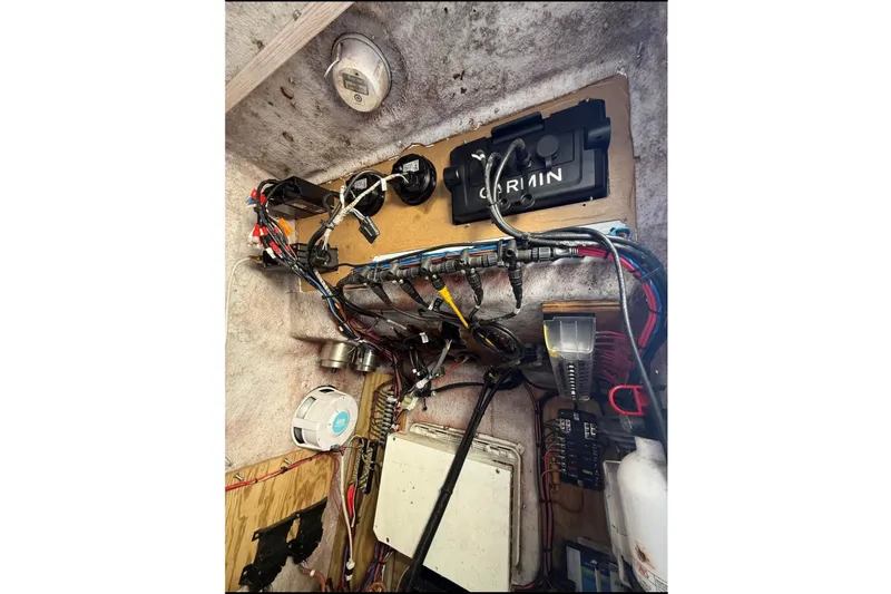 Slide: The Image of Electronics and wiring system inside a boat, featuring a Garmin device and various connections. - 13