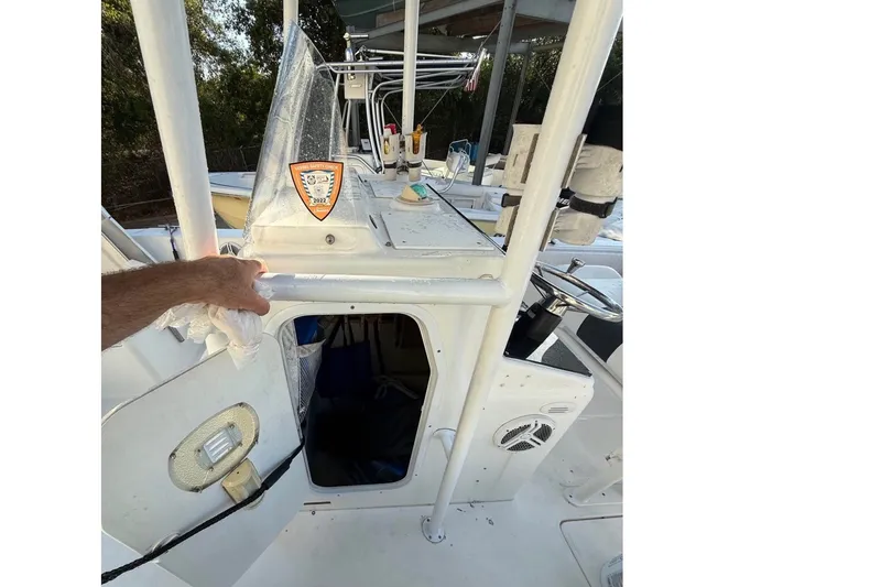 Slide: The Image of A 2004 Sea Fox 257 Center Console with an open cockpit and helm, surrounded by trees. - 15