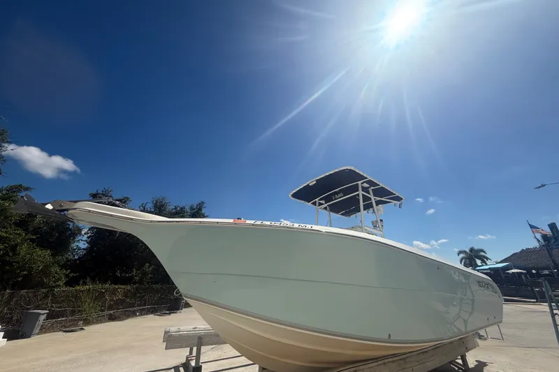 The Image of 2004 Sea Fox 257 Center Console boat under bright sun, on a trailer. - 0