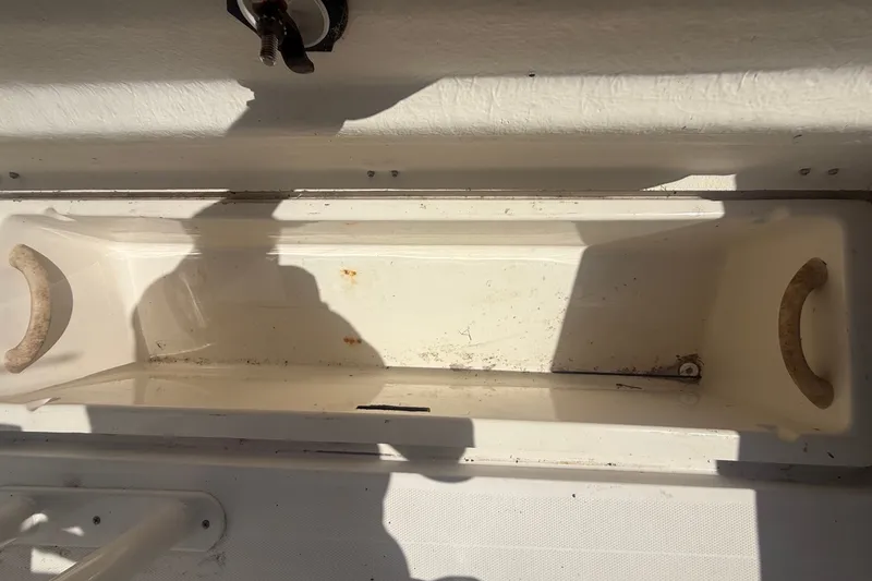 Slide: The Image of An open storage compartment on a boat with worn handles and shadows. - 44
