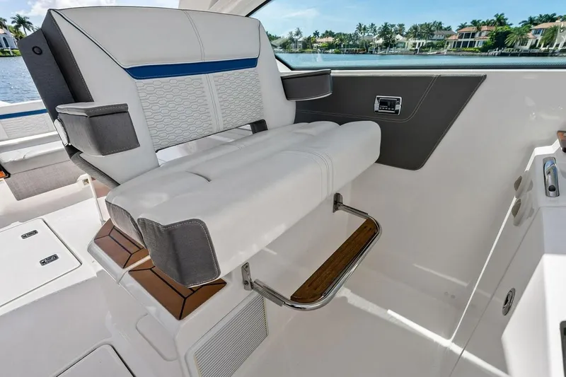 Slide: The Image of Captain's chair on 2020 Tiara 38 LX boat, featuring luxurious white and gray upholstery. - 27