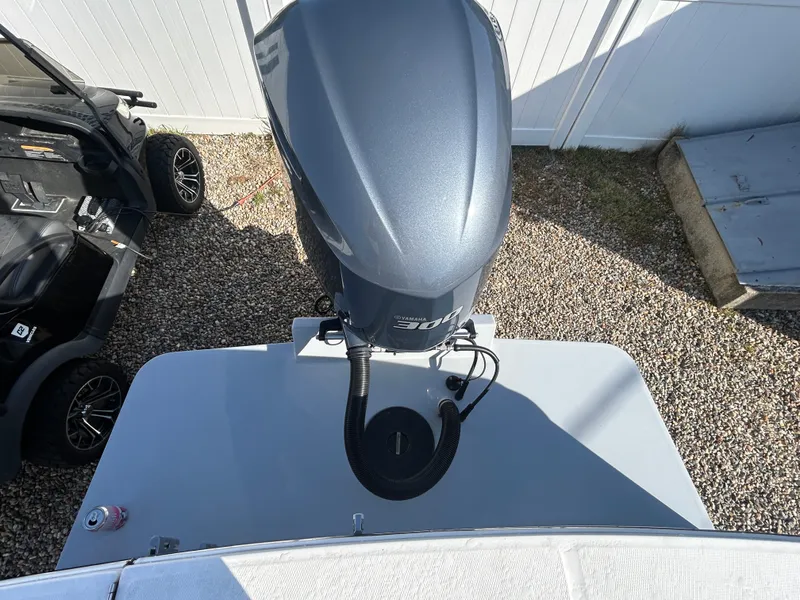 Slide: The Image of A 2020 Regulator 23 with an outboard motor, parked on a gravel surface. - 24