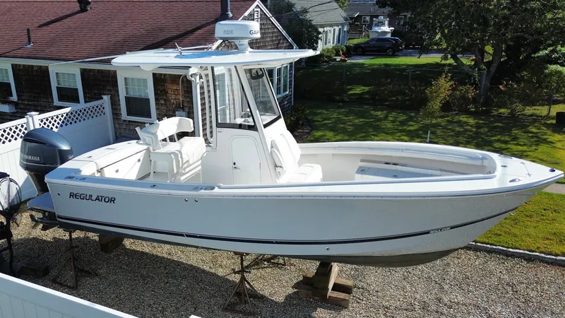 The Image of A 2020 Regulator 23 boat is on a gravel lot in front of a house. - 0