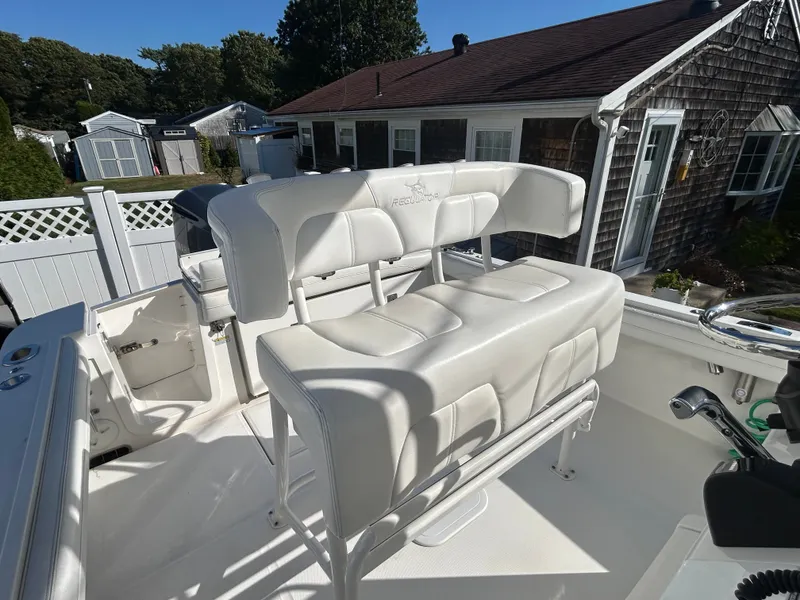Slide: The Image of The image shows a white bench seat on a boat, surrounded by houses in the background. - 18