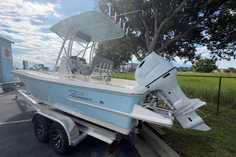 Slide: The Image of 2027 Pioneer 220 Bay Sport boat on trailer, parked outdoors under a tree. - 5