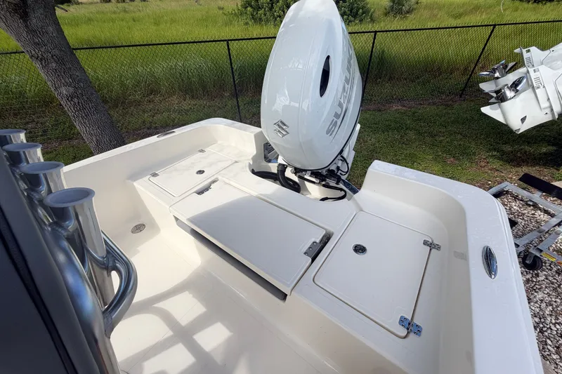 Slide: The Image of 2027 Pioneer 220 Bay Sport boat with Suzuki outboard motor, featuring spacious deck and storage compartments. - 17