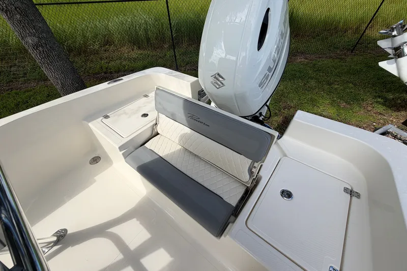 Slide: The Image of 2027 Pioneer 220 Bay Sport boat interior with seating and Suzuki outboard motor. - 19