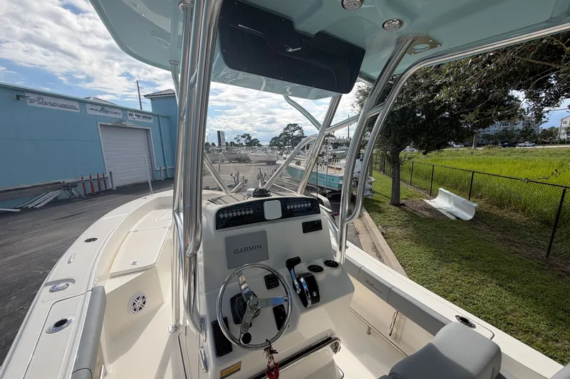 Slide: The Image of 2027 Pioneer 220 Bay Sport boat interior with Garmin navigation system, parked outdoors. - 6