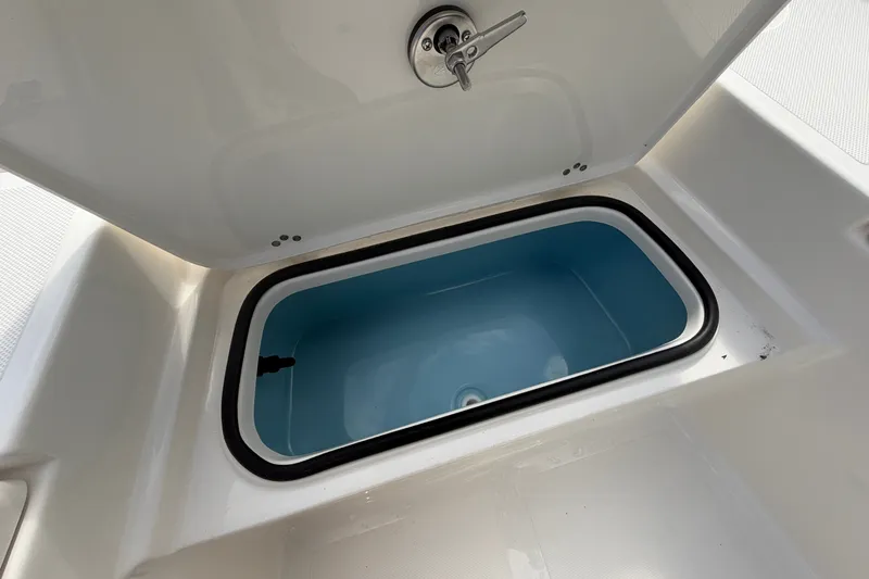 Slide: The Image of Open storage compartment on 2027 Pioneer 220 Bay Sport boat, featuring a blue interior. - 12