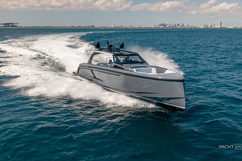 Slide: The Image of 2025 Vanquish Yachts VQ55 cruising on open water, city skyline in background. - 5