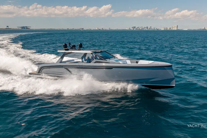 Slide: The Image of 2025 Vanquish Yachts VQ55 cruising on open water with city skyline in background. - 6