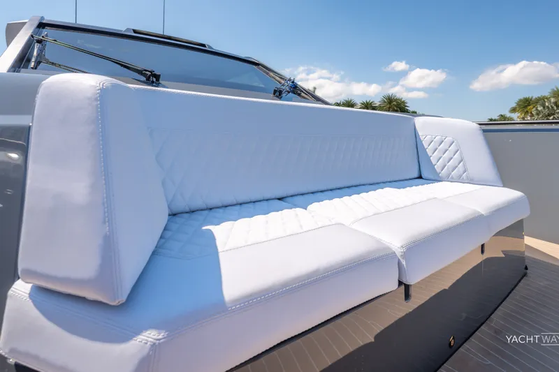 Slide: The Image of Luxurious white seating on 2025 Vanquish Yachts VQ55, under clear blue sky. - 24