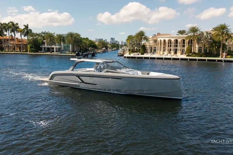 Slide: The Image of 2025 Vanquish Yachts VQ55 cruising on a scenic waterway with luxury homes in the background. - 14