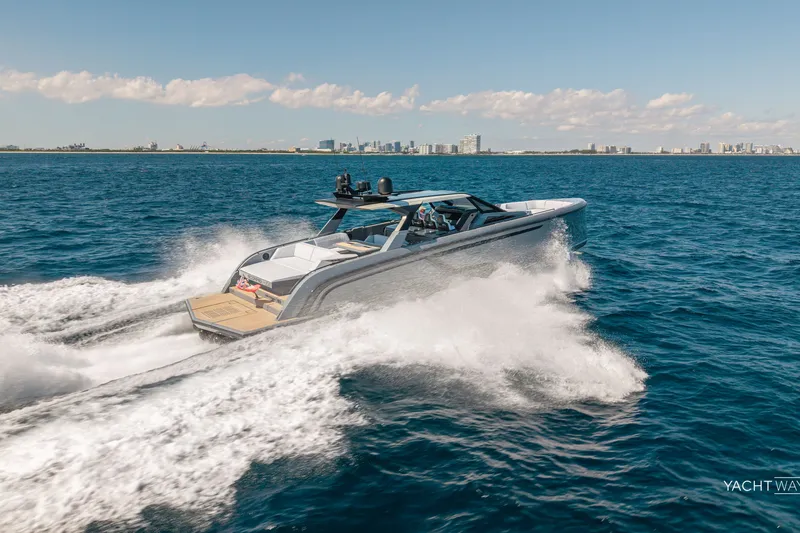 Slide: The Image of 2025 Vanquish Yachts VQ55 cruising on open water with city skyline in background. - 8