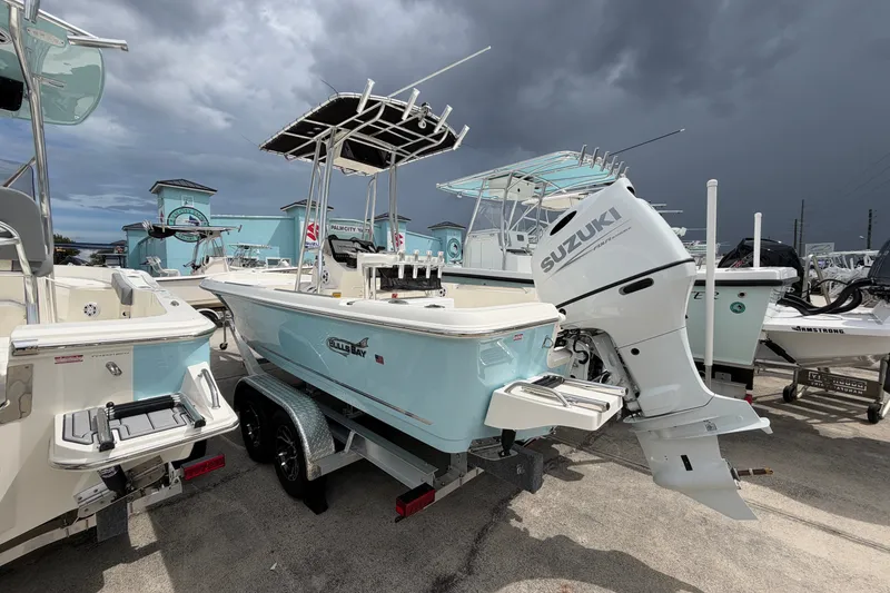 Slide: The Image of 2027 Bulls Bay 2200 XS boat with Suzuki engine, parked under stormy skies. - 3