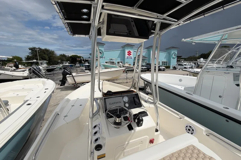 Slide: The Image of 2027 Bulls Bay 2200 XS boat with Garmin navigation, docked at a marina under cloudy skies. - 6