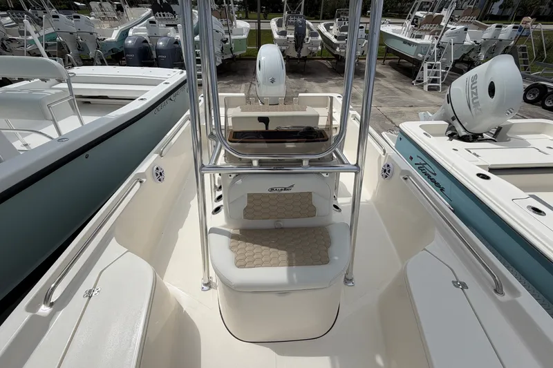 Slide: The Image of 2027 Bulls Bay 2200 XS boat interior with seating and console, docked among other boats. - 12
