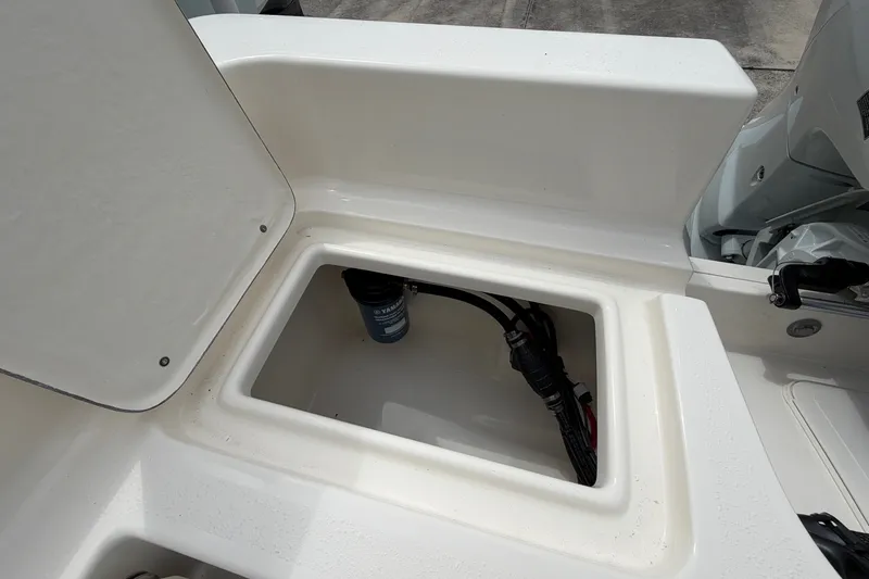 Slide: The Image of Open storage compartment on a 2027 Bulls Bay 2200 XS boat, showcasing internal wiring. - 19