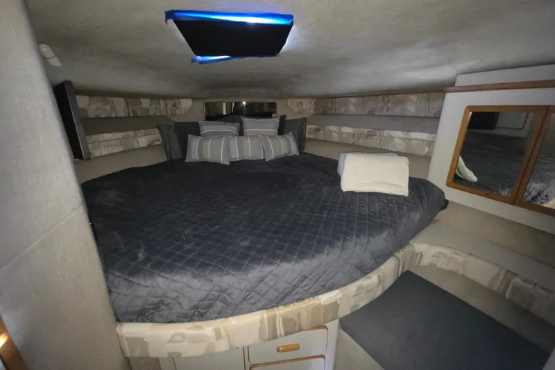 Slide: The Image of Cozy cabin interior of 1991 Sea Ray 420 Sundancer with plush bedding and ambient lighting. - 23