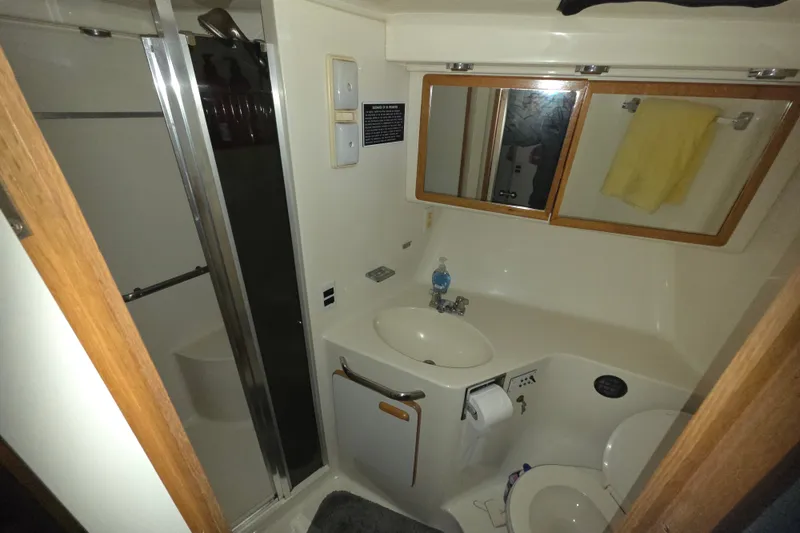 Slide: The Image of Bathroom interior of 1991 Sea Ray 420 Sundancer yacht, featuring sink, mirror, and shower. - 24