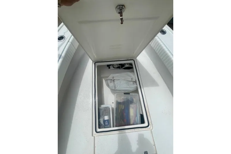 Slide: The Image of Open storage compartment on 2022 Dorado 25 FD boat, containing various items. - 25