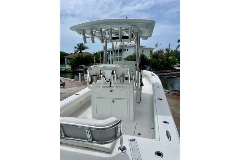 Slide: The Image of 2022 Dorado 25 FD boat with center console and rod holders, docked near waterfront homes. - 17