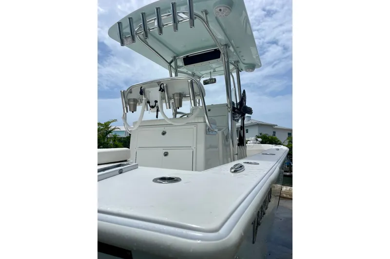 Slide: The Image of 2022 Dorado 25 FD boat with sleek design, rod holders, and center console under a cloudy sky. - 19