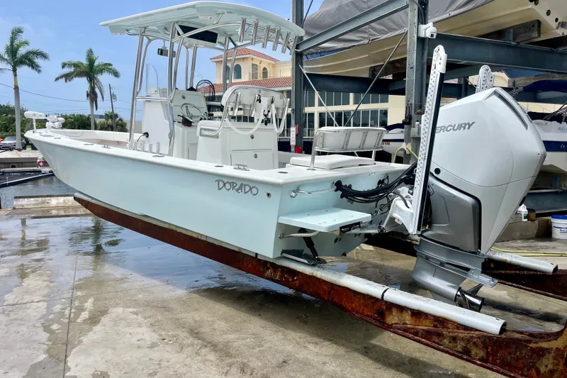 Slide: The Image of 2022 Dorado 25 FD boat with Mercury engine on a lift, dockside view. - 1