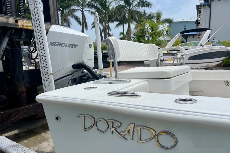 Slide: The Image of 2022 Dorado 25 FD boat with Mercury engine, docked near palm trees and other boats. - 11