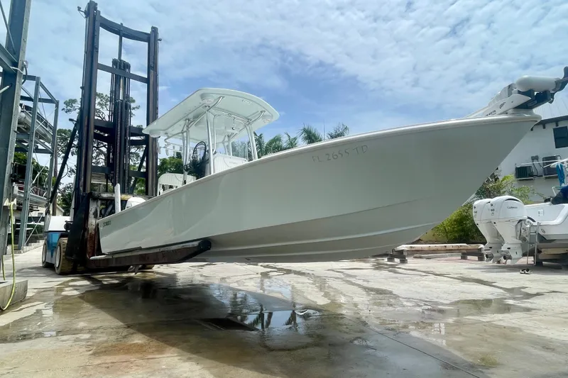 Slide: The Image of 2022 Dorado 25 FD boat lifted by forklift in marina setting. - 5