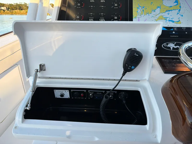 Slide: The Image of An open compartment on a boat reveals a radio and controls. A screen displays navigation data. - 49