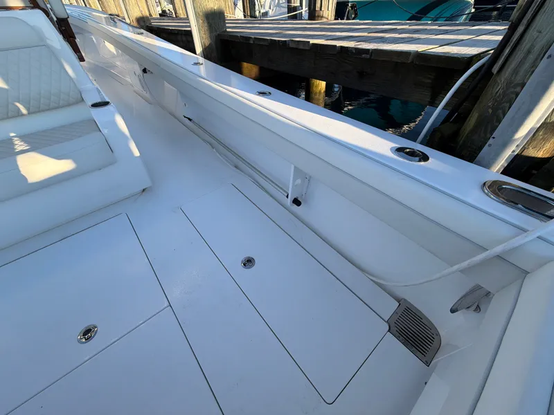 Slide: The Image of The image shows the deck of a 2026 Valhalla V-41 boat with white upholstery and storage. - 32