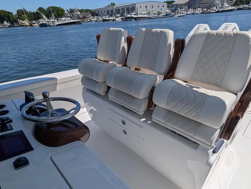 Slide: The Image of Three luxurious, cushioned seats on a boat with a sleek steering wheel and dashboard. - 25
