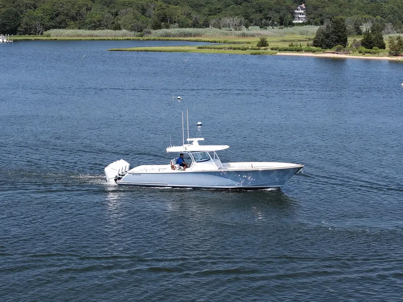 Slide: The Image of 2026 Valhalla Boatworks V-41 cruising on a serene lake with lush green shoreline. - 20