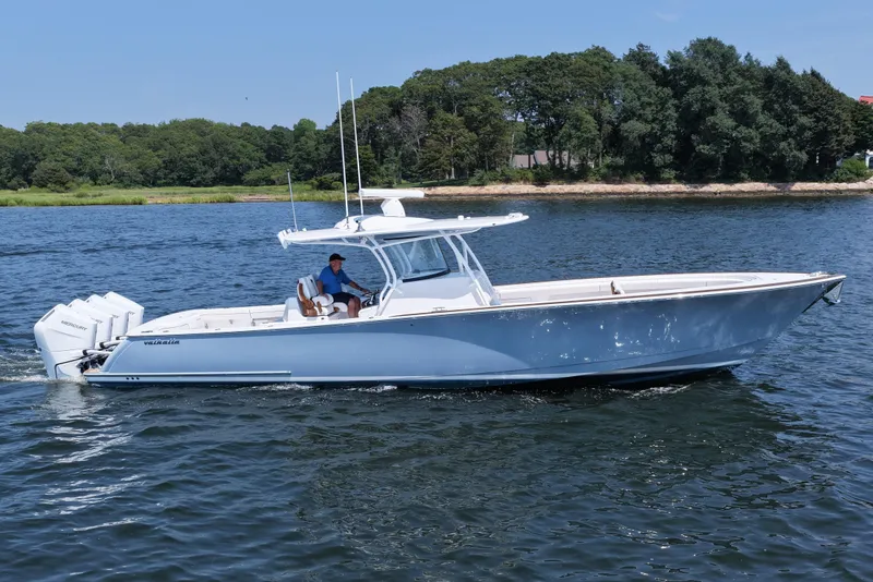 The Image of 2026 Valhalla Boatworks V-41 cruising on a serene lake with lush green shoreline. - 1