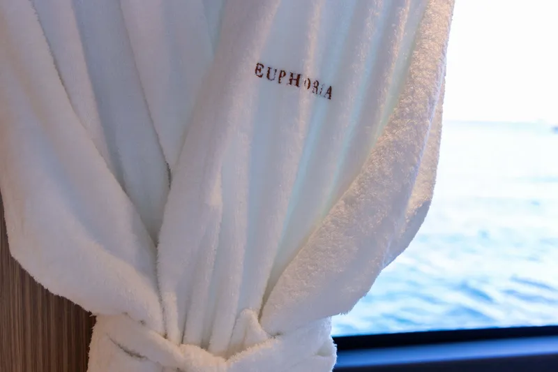 Slide: The Image of Luxurious white robe with "Euphoria" embroidery, overlooking serene ocean view. - 30