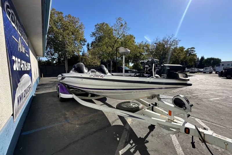 The Image of 2006 Triton TR-21 boat on trailer, parked outdoors under clear blue sky. - 0