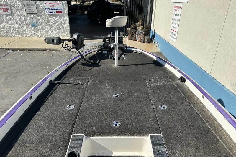 Slide: The Image of 2006 Triton TR-21 boat deck with trolling motor and seat, parked near service area. - 8