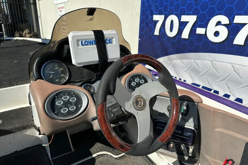 Slide: The Image of 2006 Triton TR-21 boat dashboard with steering wheel and Lowrance device. - 13