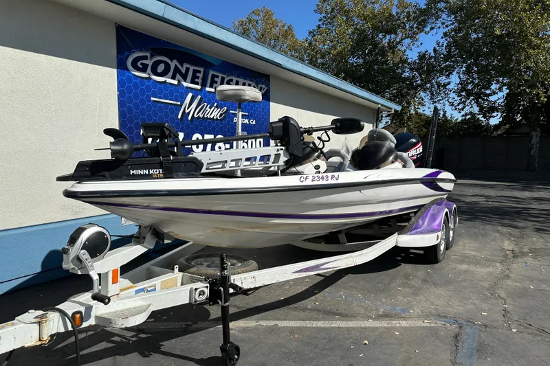 Slide: The Image of 2006 Triton TR-21 boat on trailer, parked outside marine shop, featuring Minn Kota trolling motor. - 2