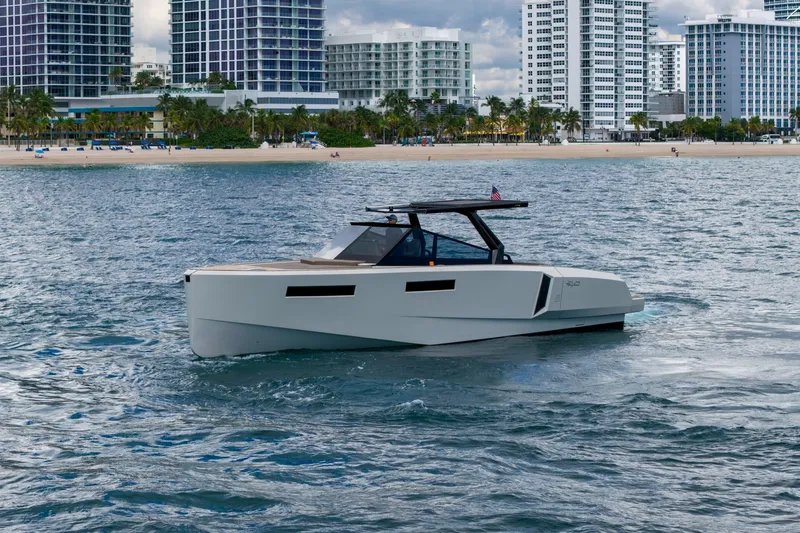 Slide: The Image of 2023 Evo Yachts R4 WA cruising near a city shoreline with modern buildings. - 4