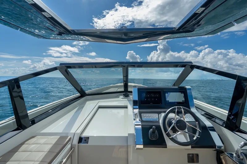 Slide: The Image of Cockpit view of 2023 Evo Yachts R4 WA, showcasing modern steering and ocean backdrop. - 48